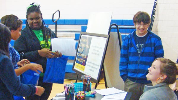 Polk County’s Virtual Early College’s students Vincent Gage (standing) and Callie Keeter (seated) participated in the Polk County Middle School’s annual Career Day. They answered questions about the Early College and explained some of the benefits of enrolling there. In the photo, eighth graders Danielle Greer and India Anderson get first hand information from the Virtual Early College students. (photos submitted)