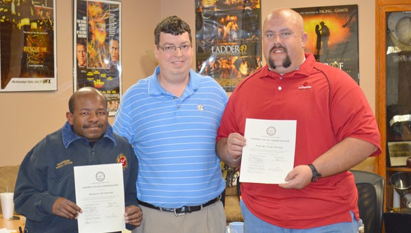 Pictured is Tryon Fire Chief Joey Davis, center,  presenting firefighters Marshall Lipscomb (at left) and Tank Waters (at right) with proclamations in recognition of their recent response to a patient at White Oak Village who was experiencing an allergic reaction. Davis told town council at its March 19 meeting that if had not been for the actions of Lipscomb and Waters the person would not have survived. (photo by Leah Justice)