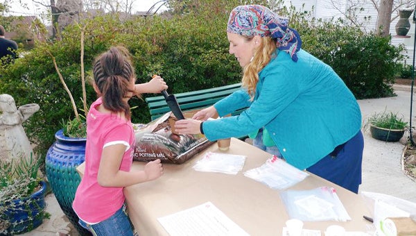 Mindy Weiner helps a young member of the community put together a plant to take home. (photo submitted)
