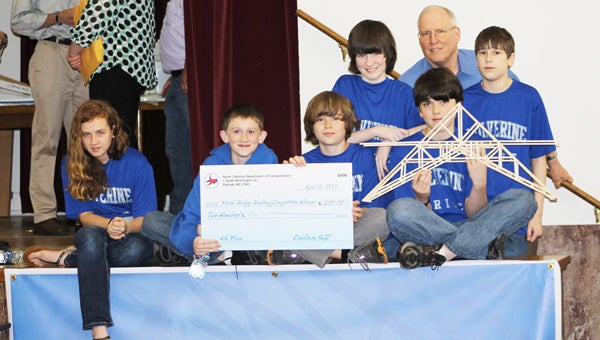 Polk County Middle School students Taylor Warren, Tiler Pace, Hayden Gary, Sam Rhinehart, Noah Frazier, Dr. Pettis and Samuel Kornmayer hold a check for $200 after placing fourth at the state finals for model bridge building. (photo submitted)