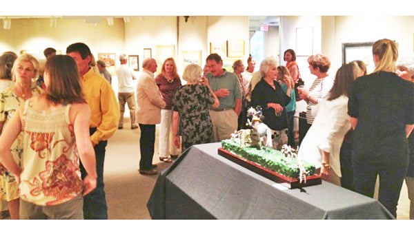 Community members peruse the equestrian art exhibit at the Tryon Fine Arts Center. (photo submitted)