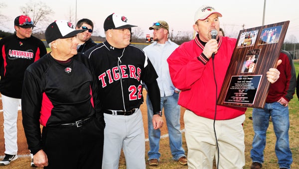 Landrum Athletic Director John Cann presents a plaque to Jerry Henson (left) and Travis Henson (center), as he recalls their accomplishments in coaching the 2002, 2005 and 2007 Landrum teams to state championships. (photo by Mark Schmerling)