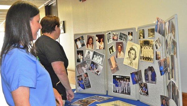 In celebration of National Nurses Week, Tracy Cates and Gayle Rape help arrange a photo collage of St. Luke’s Hospital Nurses through the years. (photo submitted by Kathy Woodham)