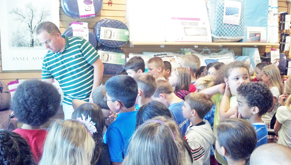 Second grade students at Polk Central Elementary School recently visited local businesses in Columbus and Tryon. While on their field trips, they learned about economics and financial literacy. Shown here, students learn about Link Medical and Stott’s Ford businesses. (photos submitted by Lisa Pritchard)