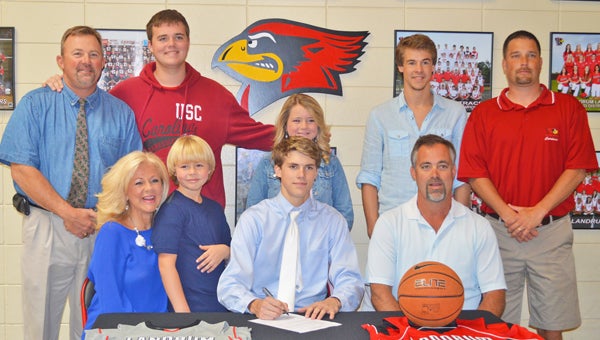 Daniel Bridges signs to play with USC Upstate surrounded by family and LHS staff. Shown are front row, left to right: mother, Kelly Bridges; Harrison Bridges, Daniel Bridges; dad, Dean Bridges; top row, left to right: LHS athletic director John Cann, Erinn Bridges, Anna Grace Bridges, Bradley Bridges and Coach Lyn Smith. (photo by Samantha Hurst)