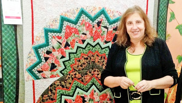 PJ Steinman of PJ’s Fashions in Landrum is displaying a quilt entitled Aztec Headdress as part of a downtown exhibit provided by the Landrum Quilters. The contemporary quilt artist, Marilyn Doheny of Tryon, will be the featured quilter at the June 13-15 Landrum Quilt Show. The event takes place in the gym at Landrum Middle School, 104 Redland Rd. Other quilts are hung at American Designs, First Citizens Bank, God’s Creatures, Landrum City Hall, the Landrum Library, The Mail Room, Vera and Woodcreek Dental. The 2013 show quilt is hanging at Elaine’s Attic. For more information about the quilt show, visit www.landrumquilters.com. (photo submitted by Ellen Henderson) 