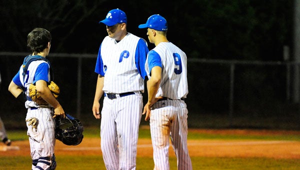 Late in the game, Polk catcher Bryce Martin, left, and head coach Ty Stott, confer with Alec Philpott on the mound. (photo by Mark Schmerling)