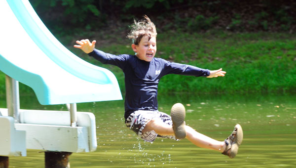 Saluda Community Land Trust (SCLT) board members worked nearly non-stop to prepare the well-known water slide at its Twin Lakes Park for the park’s grand-reopening on Saturday, June 14. Larkin Mraz, right, celebrated his seventh birthday in great style, with several trips down the steep slide and into the refreshing water of the park’s upper lake. See page 4 for the story and more pictures. (photos by Mark Schmerling)