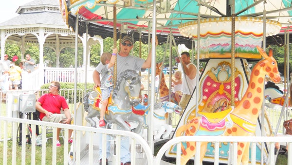 A father and son enjoy a ride on the carousel at last year’s Columbus Fabulous Fourth event. Rides open Wednesday, July 3 at 5 p.m. (photo by Samantha Hurst)