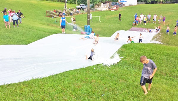 Polk County Youth Football players recently enjoyed a fun day with teammates and family. Players went down a huge makeshift slip and slide at Gibson Park in Columbus. (photo submitted by Ashley Prince)
