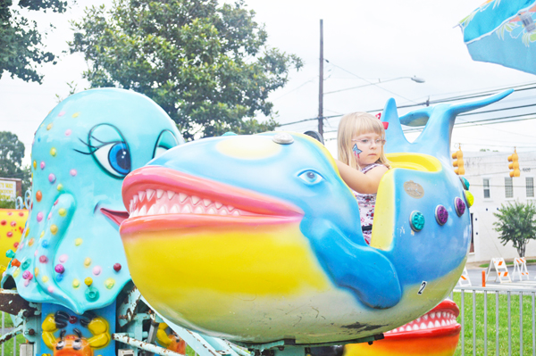 Vendors, amusement rides and fireworks will make up Columbus’ first Labor Day Weekend Festival Aug. 30-31. Kids, like this little girl shown here, had a few hours between rain storms July 4 to enjoy rides. (photos by Samantha Hurst)