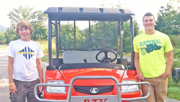 This past summer, the Polk County Community Foundation funded two interns, Hunter Hilbig, left, and Will Ballard, right, for the Polk County High School Farm. The students were responsible for assisting in the daily operations of maintaining the farm grounds, equipment and animals.  Chauncey Barber, agricultural education instructor said, “We are thankful for the foundation’s continued support of our agricultural education program.” (photo submitted by Chauncey Barber)
