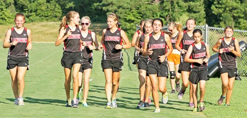 The Cardinal’s girls cross country team takes a cool-down run after dominating the course at Woodruff High School. LHS’ girls team aims to make another run at the state championship this year. The team won state last year, despite moving up to 2-A from 1-A. (photo by Lorin Browning)