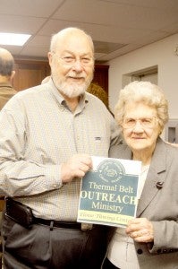 Thermal Belt Outreach Ministry Board of Directors President Joe Epley with Eloise Thwing and a printed version of the campus’ new sign. (photo by Kiesa Kay)