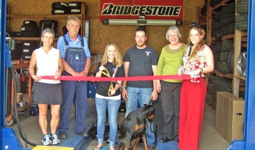 Foothills Chamber of Commerce welcomes new member, Atkins Tire. Pictured are Chamber Board member Kathy Toomey of New View Realty,  Michael Atkins (father), Anna Atkins (wife) with scissors, J. C. Atkins and their dog Cooper, his mother Heather Atkins, and Chamber Board member Dulcie Juenger of Walker-Wallace & Emerson Realty. (photo submitted by Janet Sciacca)
