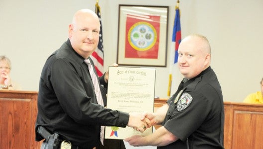 Columbus Police Chief Chris Beddingfield (left) presents officer Jerry Williams (right) with his advanced law enforcement certificate from the North Carolina Criminal Justice Education and Training Standards Commission during Columbus Town Council’s Thursday, April 17 meeting. (photo by Mark Schmerling)