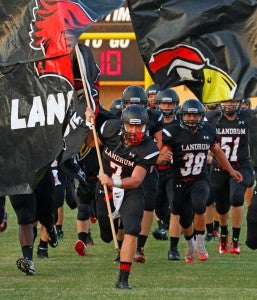 Led by Caleb Pruitt, the Cardinals enter the field through the spirit line Photo by Lorin Browning