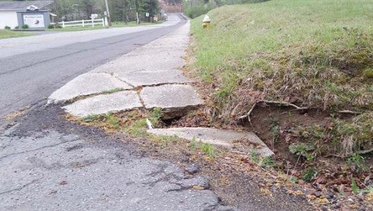 Tryon commissioner George Baker has called for the town to form a committee made up of residents to help the town inventory and address sidewalk repairs and where new sidewalks should be installed throughout town. Pictured is a sidewalk on Hwy. 176  in need of repairs. (Photo by Leah Justice)