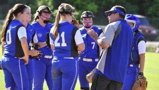 Polk varsity softball coach Jeff Wilson has a word with his battery and infielders. (Photo by Mark Schmerling)