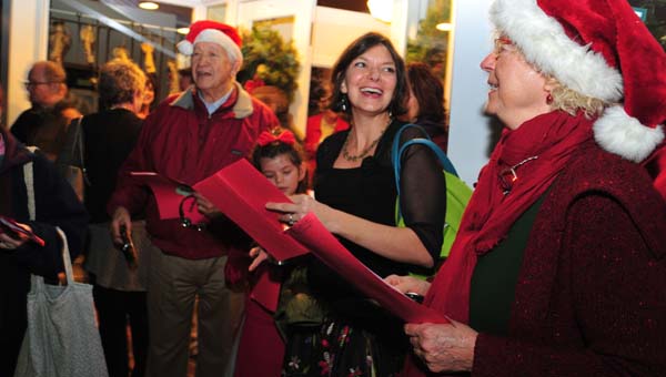 Patricia Roskens, right, leads the Saluda Community Choir when that group went caroling recently at Saluda's Hometown Christmas event.