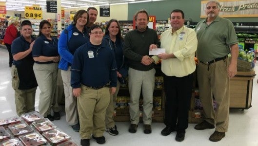 Kurt Dills, manager of the Columbus Food Lion, and Food Lion team members present Outreach’s executive director, George Alley, with a check for the $2,500 grant.