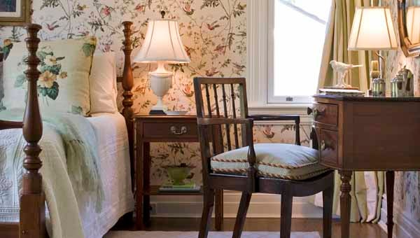 In this guest room, a lovely English wallpaper with birds and flowers gives the room an air of lightness, joy and comfort. Photo by Tim Lee. Design by Drummond House.