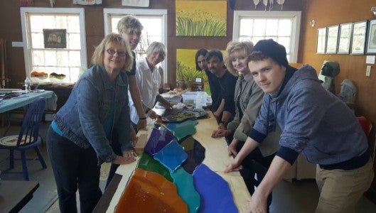 Susan Cannon, Logan Bates, Susie Hearn, Jericho Thomas, Jeff Thomas, Suzanne Warrick and Caelum McCall are a team that has been working on setting up glass murals around Saluda since the summer of 2015. Each mural represents Saluda’s mountains, waterfalls and railroad history and will be permanent installations in the town after being unveiled at the Saluda Arts Festival.